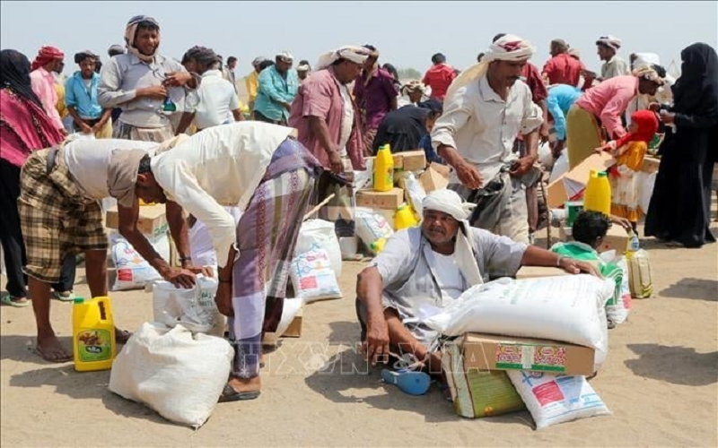 Người dân nhận hàng cứu trợ tại một trại tị nạn ở thành phố Hodeidah, Yemen ngày 31-8-2022. Ảnh: AFP/TTXVN