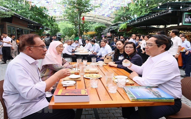 Thủ tướng Phạm Minh Chính và Phu nhân cùng Thủ tướng Malaysia Anwar Ibrahim và Phu nhân thưởng thức cà phê tại Phố sách Hà Nội. (Ảnh: Dương Giang/TTXVN)